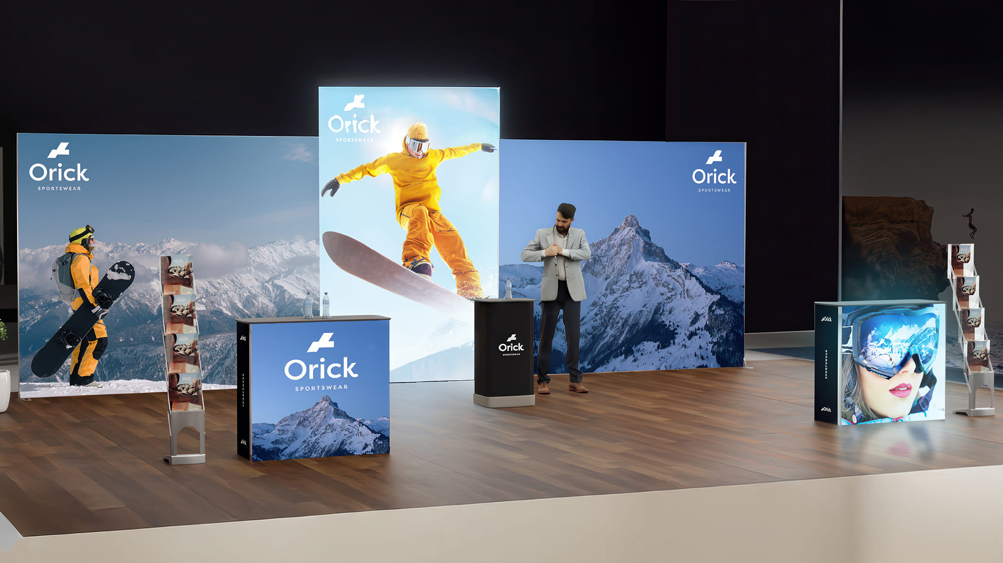 Een beursstand toont het merk Orick Sportswear met afbeeldingen van snowboarders, bergen en skibrillen; een man in pak staat achter de hoofdbalie.